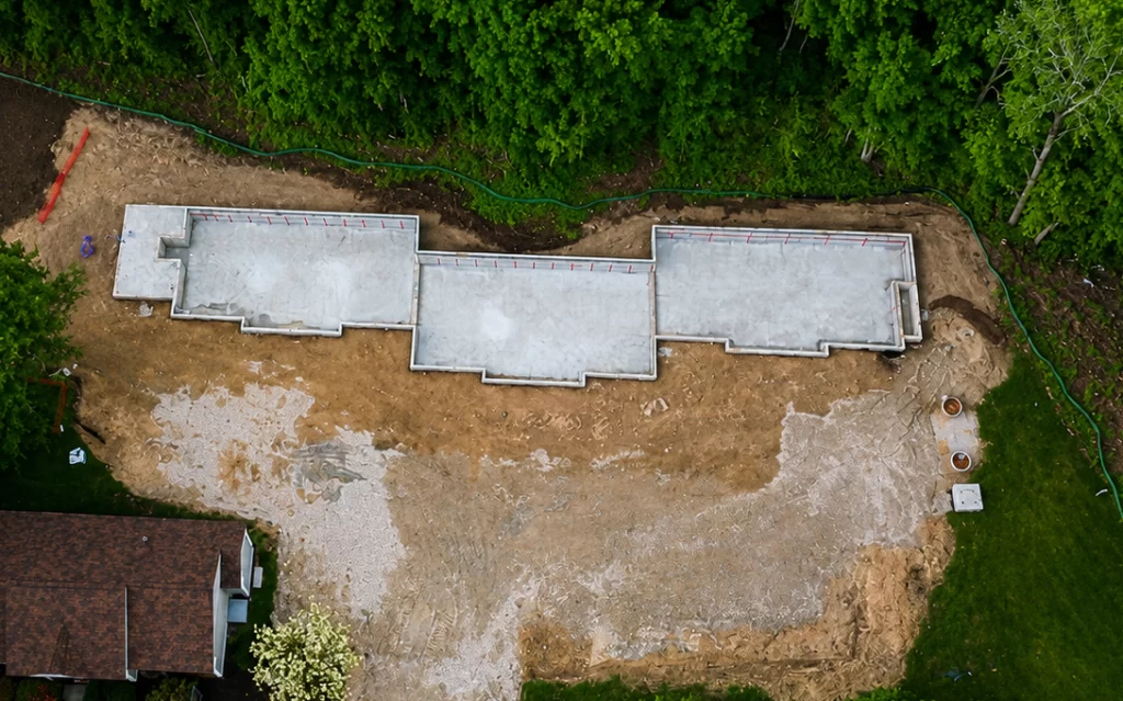 Overhead aerial view of the completed six-unit building foundation and surrounding construction site at Pelham Terrace in Pelham, NH.