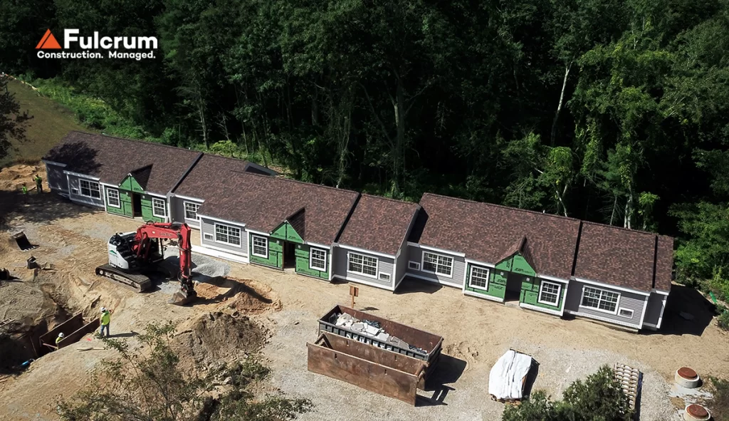 Aerial drone view of the new six-unit residential building at Pelham Terrace in Pelham, NH, showing completed roofing, exterior siding, and ongoing sitework.