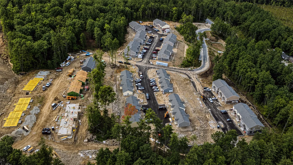 Aerial drone view of Brookline Woods in Brookline, NH, showing workforce housing buildings, new senior housing construction, and ongoing site development.